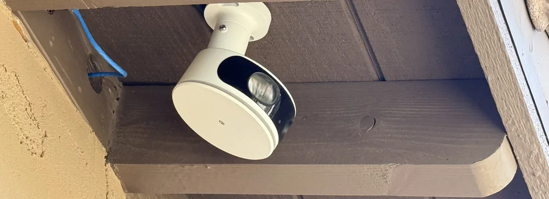 A MOBOTIX MOVE 180° camera mounted under a house eave with its network cable run along the beam